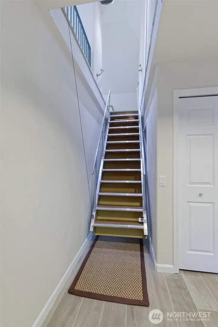 This is an ELECTRIC staircase that you bring down when you want to go up to the 3rd story. Retract it, and the hallway is clear to traverse.
