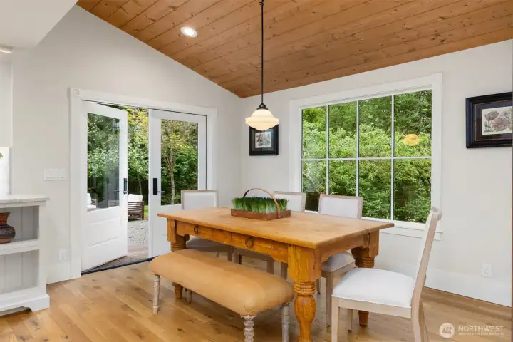 The dining room, with tongue and groove vaulted ceiling, has west and southern light and French doors to outdoor space.