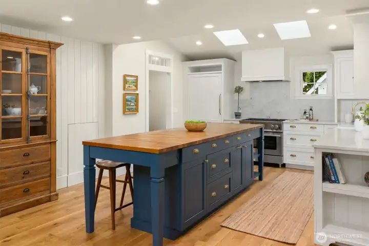 Marble countertops and butcher block on the island, add to the kitchen's timeless design.