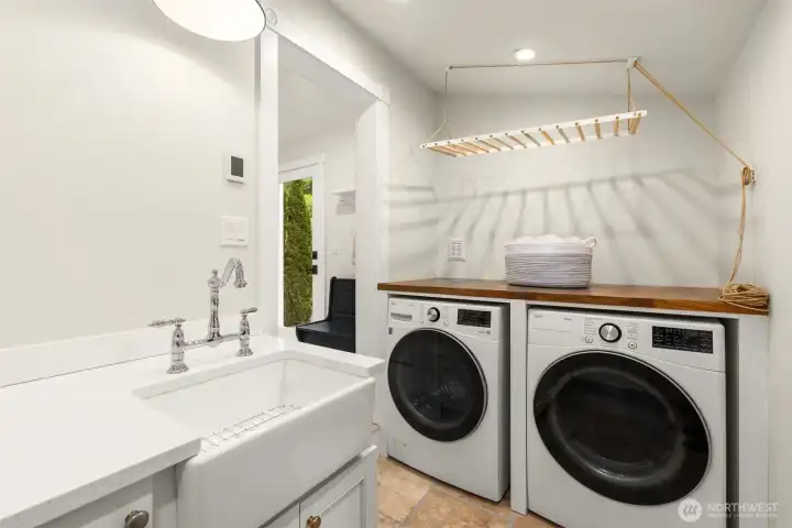 Separate laundry room with farm sink, radiant heated floors, and custom cabinetry make this space both useful and elegant.