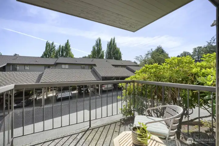 Balcony with Views:  Enjoy fresh air and sunshine from this charming private balcony offering city and neighborhood views. The space is perfect for morning coffee or evening relaxation, featuring a cozy seating area surrounded by lush greenery. The covered design provides shade while maintaining an open feel, and the sleek metal railing adds a modern touch. With its peaceful outlook and connection to nature, this balcony extends the home’s living space beautifully.