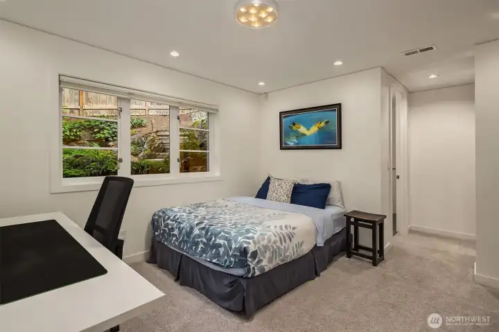 Lower level bedroom with en-suite bath in background. Lower level bedroom with en-suite bath in background.