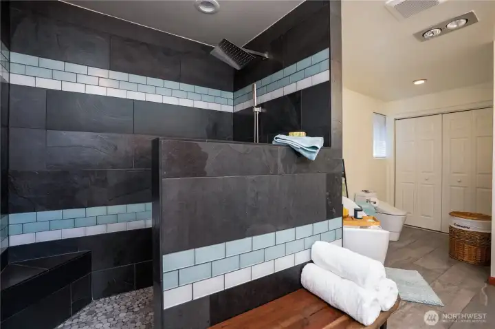 5 piece primary bathroom with a washer/dryer included behind the folding doors.