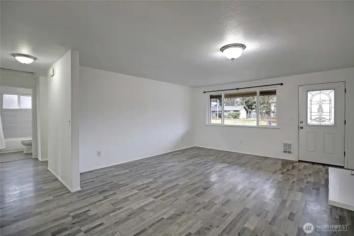 Easy maintenance laminate flooring throughout most of the home. View looking from dining room.