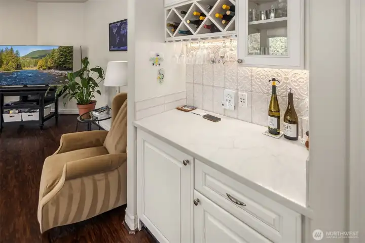 The wet bar area in the Family Room with mini fridge, wine bottle holder, and custom cabinetry