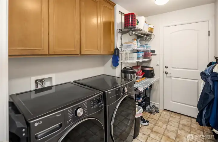 Main Level Laundry Rm w/ nice cabinet space, Full Size Front Load W&D, and sink area