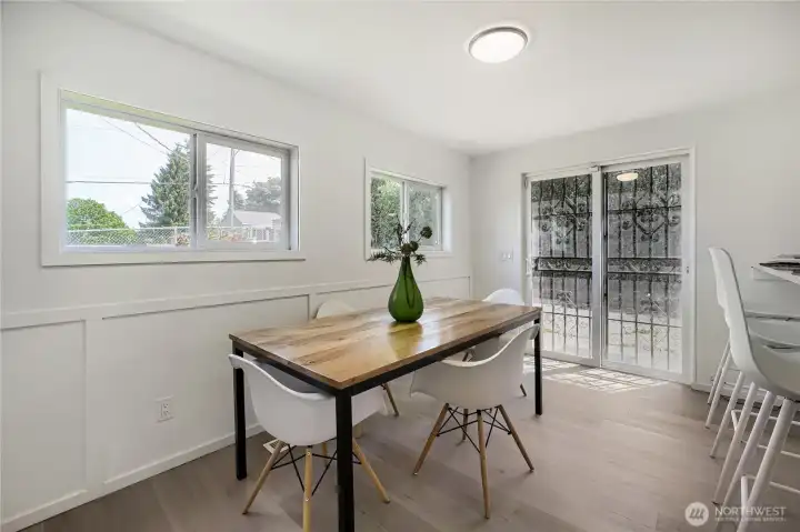 This bright dining space sits within the kitchen, offering a seamless connection to the back patio and yard. Large windows and glass doors fill the room with natural light, creating an airy, welcoming atmosphere perfect for everyday meals or casual gatherings. The clean lines and light finishes enhance the home’s modern aesthetic while emphasizing its open, indoor-outdoor flow. This bright dining space sits within the kitchen, offering a seamless connection to the back patio and yard. Large windows and glass doors fill the room with natural light, creating an airy, welcoming atmosphere perfect for everyday meals or casual gatherings. The clean lines and light finishes enhance the home’s modern aesthetic while emphasizing its open, indoor-outdoor flow.