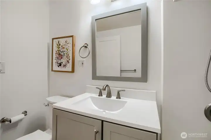 This stylish bathroom features a modern vanity with clean lines and a sleek white countertop. Brushed-nickel fixtures and a framed mirror add a touch of sophistication, while soft lighting and neutral tones create a calm, contemporary feel. Thoughtfully designed for both function and style, this space offers a polished look that complements the home’s overall aesthetic. This stylish bathroom features a modern vanity with clean lines and a sleek white countertop. Brushed-nickel fixtures and a framed mirror add a touch of sophistication, while soft lighting and neutral tones create a calm, contemporary feel. Thoughtfully designed for both function and style, this space offers a polished look that complements the home’s overall aesthetic.