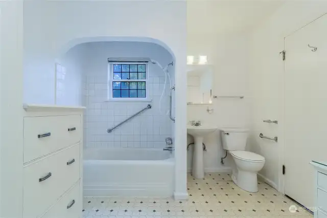 A full bathroom with covered bath/shower combo & wonderful built-ins