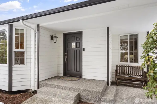 The curved walkway through the manicured front yard leads to the charming front porch, welcoming you inside.