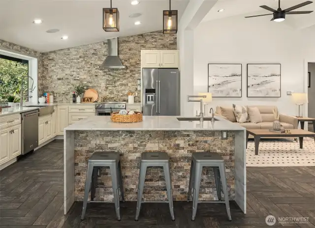 Island kitchen with waterfalled marble counters and stacked stone details.