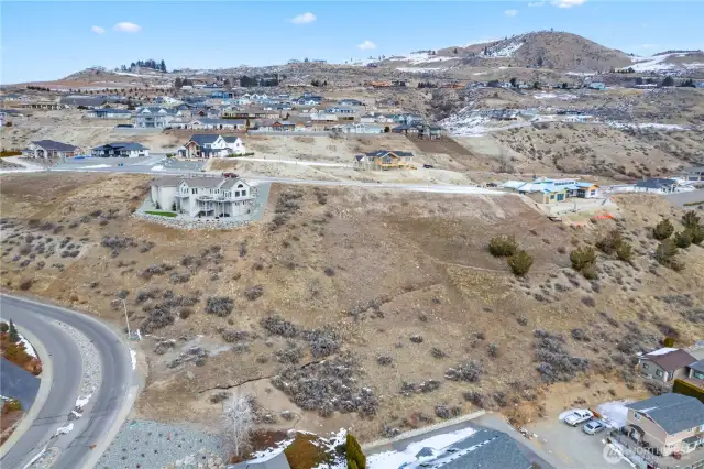 The lot at 128 Crystal Crest Dr is the only lot between the new blue sheeted roof on the right and the established home on the left as you look at this photo.