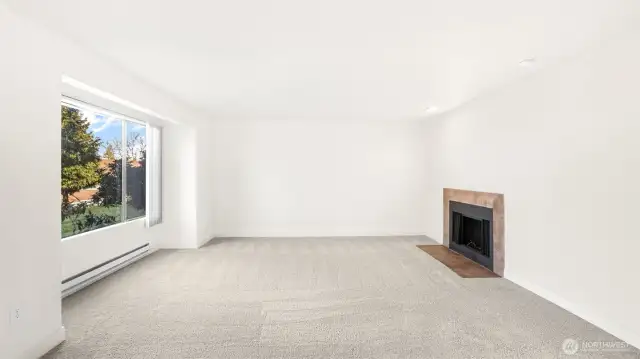 The living room offers the perfect ambiance with the natural light and the cozy fireplace.