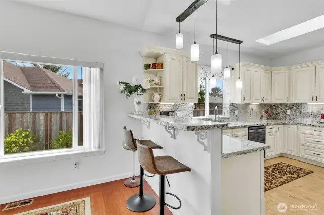The breakfast bar is large enough for 2-3 bar stools. It can also serve as a buffet for social occasions with family or friends. Designer pendant lighting and slab granite counters ad a touch of elegance.
