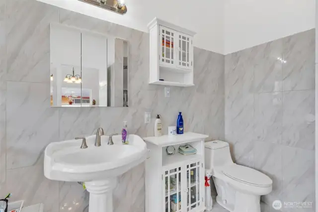Primary bathroom with pedestal sink, elongated lavatory and walk in shower.