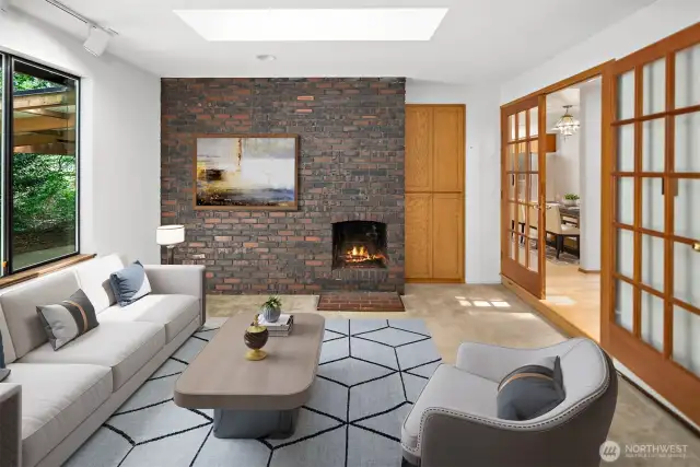 Virtually staged living room with fireplace and French doors.