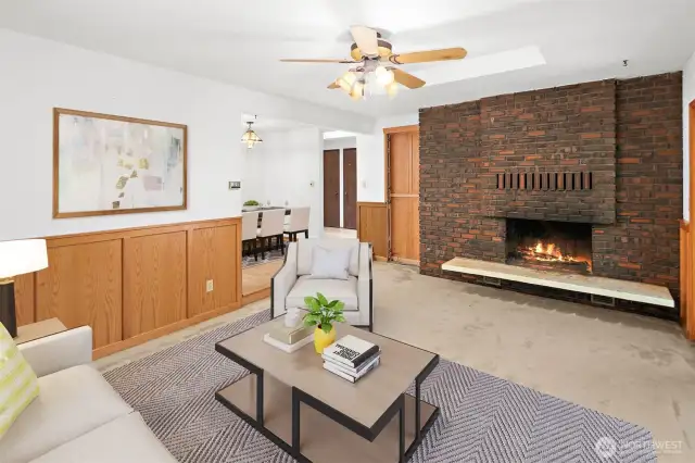 Virtually staged family room with fireplace and ceiling fan.