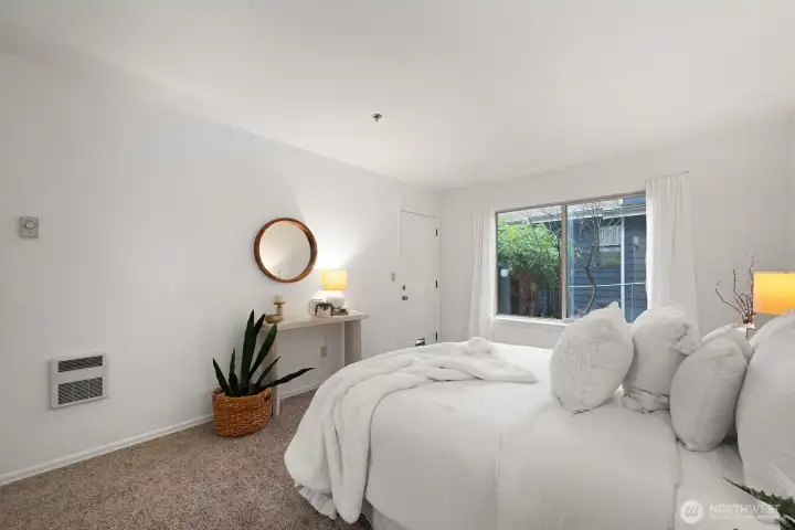 Room also features a large sliding window and an exterior door out to the patio.