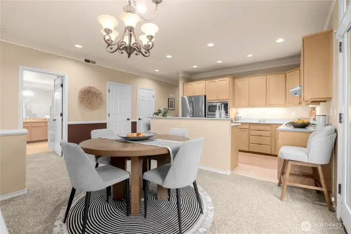 This photo shows dining to kitchen. The open door is to the primary suite and the two closed doors are the pantry closet and utility room.