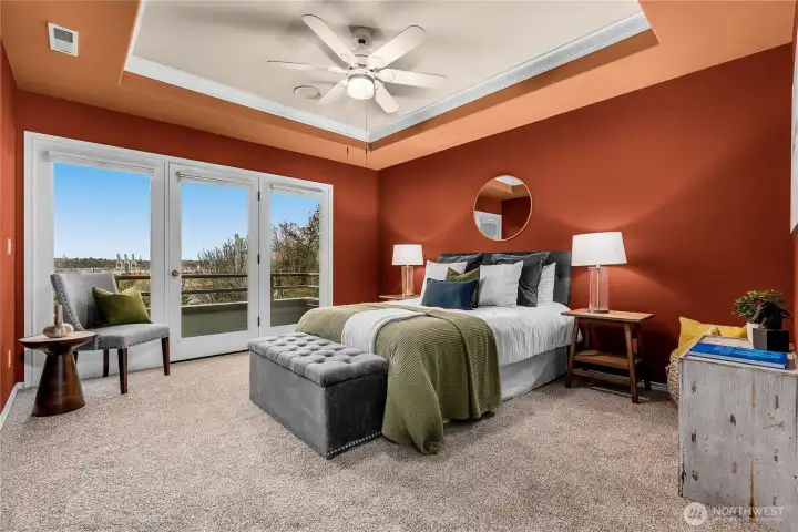 The main bedroom/primary suite is massive in size with this incredible wall of windows and door to the private deck facing the view.