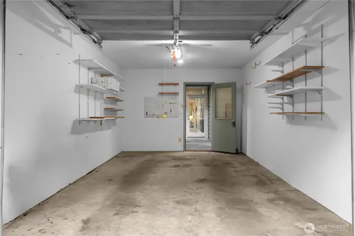 The individual garage has built-in shelves. Great for parking and/or storage. That next door straight ahead is the entrance to the home.