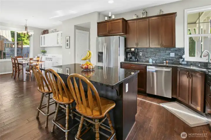 Kitchen & Dining:  Designed for connection and comfort, this kitchen flows easily into the dining area, creating a bright and open atmosphere. The large island with seating invites conversation, while rich cabinetry, granite counters, and stainless appliances combine style with everyday functionality.