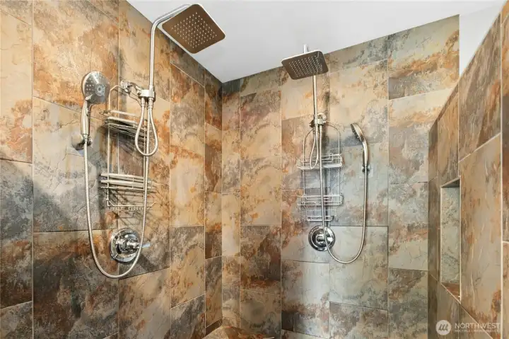 Primary Shower:  Step into comfort with a beautifully tiled walk-in shower featuring dual rainfall heads and rich natural stone tones. Designed for both relaxation and convenience, this space blends spa-like luxury with timeless craftsmanship.
