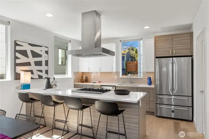 Stunning chef’s kitchen with upgraded appliances, abundant counter space and cabinetry, a pantry, and south- and west-facing windows.