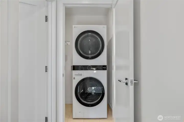 Washer and dryer closet on the upper level, conveniently located off the primary bedroom, with space for hanging clothing.