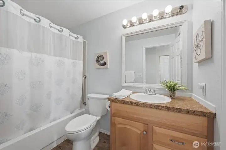 Full bath with updated cabinets and flooring