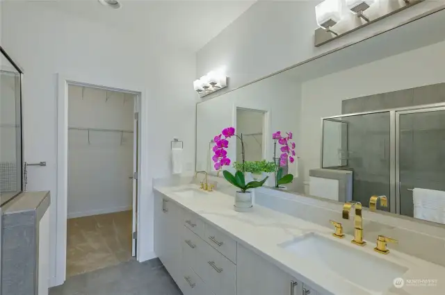 Spa like primary suite bath with beautiful quartz upgrade and large walk-in closet.