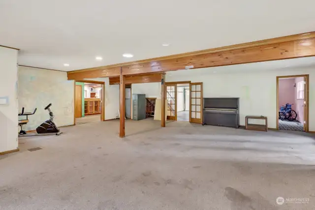 The great room looking toward kitchen, stairs and utility hallway. A small main floor bedroom with bathroom is shown on the right.