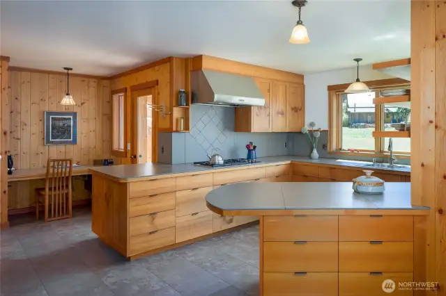 Spacious kitchen in the main home with tile counters and floors.