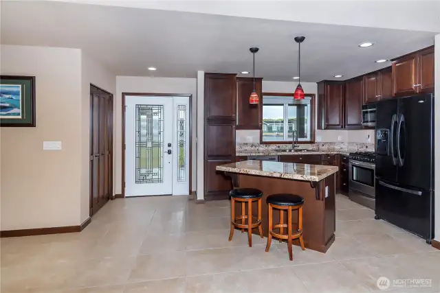 Beautiful glass front door, entry closet/pantry and open kitchen