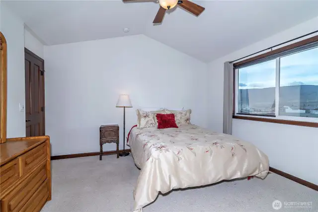 Primary bedroom with ceiling fan and views of the river