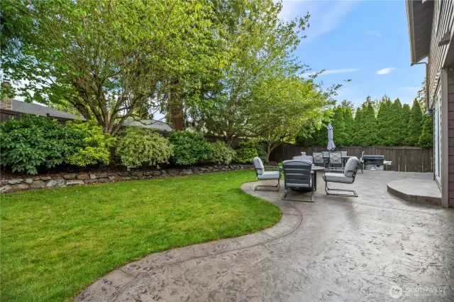 Private backyard with mature landscaping and multiple seating areas for relaxing or entertaining.