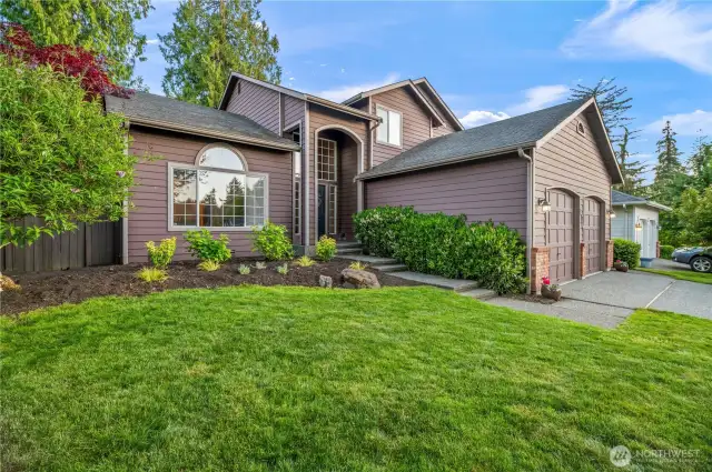 Beautiful curb appeal with fresh landscaping, arched windows, and a welcoming covered entryway sets the tone for this stunning home.