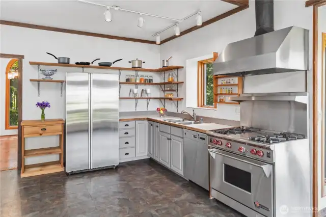Former owners removed the cabinets and installed shelving. Opportunity knocks for you to create your own dream kitchen, starting with great space and a Wolf range and gas stove top.
