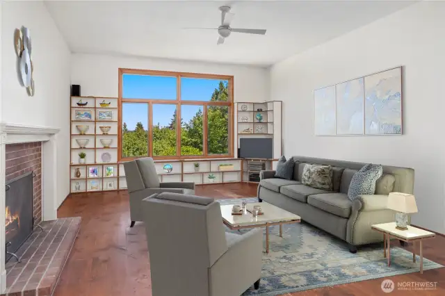 The great room has a large viewing window that faces East over the gardens. The wide real wood floors with cut nails are gorgeous, and in need of re-finishing on the lower level. The wood shelving in the background can easily be removed if preferred. Lots of wall space to hang your beloved art!