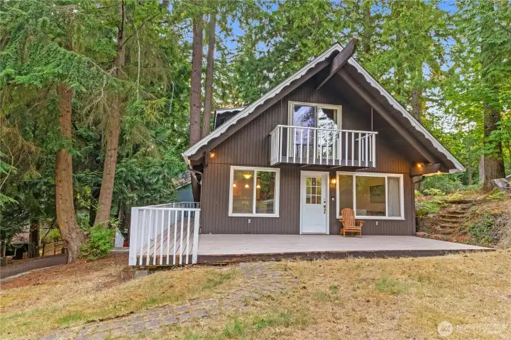 A-Frame cabin with large front deck that wraps along the side.