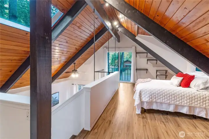Upstairs is a massive lofted primary bedroom