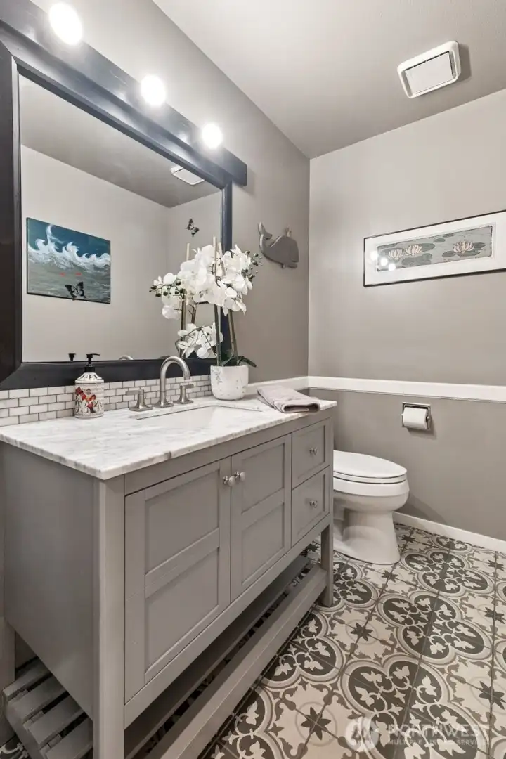The updated main floor powder room features fresh finishes and a modern vanity. Guests will appreciate its elegant simplicity and convenient location.