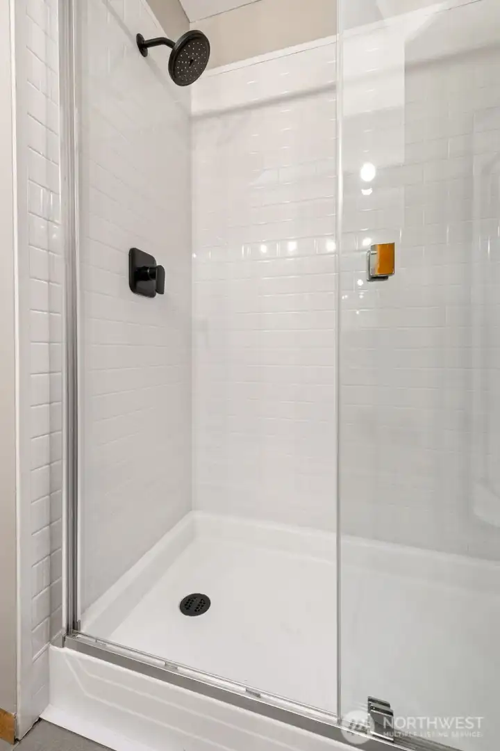 Guest bathroom with a new shower and stylish, matte black fixtures.