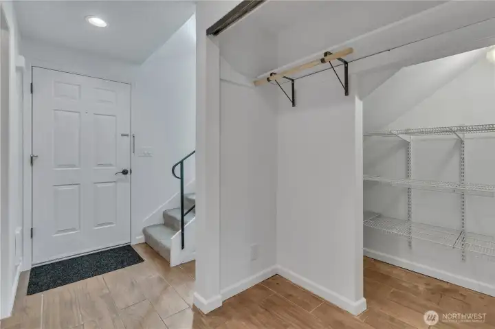 Large pantry under the stairs doubles as coat closet.