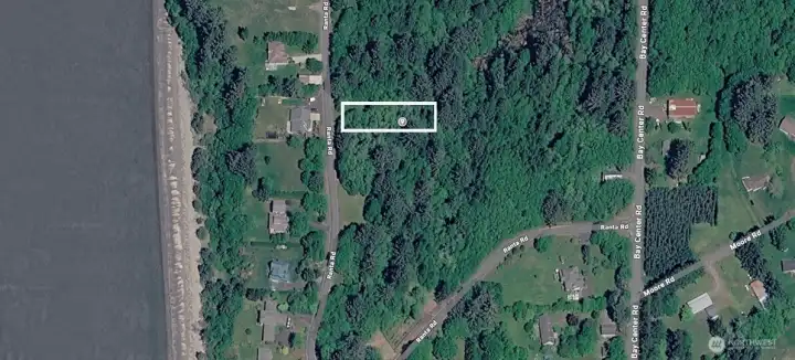 A wooded parcel near the water offering privacy and natural coastal charm.