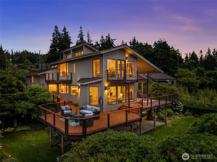 The back of home and decks to enjoy every stunning sunset from the main deck w/2 seating areas to 2 off primary suite The back of home and decks to enjoy every stunning sunset from the main deck w/2 seating areas to 2 off primary suite