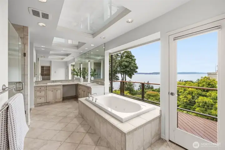 The primary bath, complete with soaking tub, dual sinks and vanity, your own private deck off the bath as well The primary bath, complete with soaking tub, dual sinks and vanity, your own private deck off the bath as well
