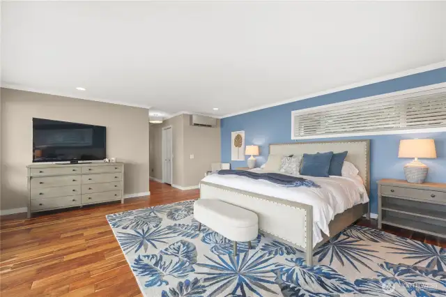 The lower level primary bedroom is a peaceful, retreat-like sanctuary with a spacious layout and expansive views- perfect for rest and rejuvenation. Clear sightlines from the bed to the windows capturing stunning views of the water and mountains.