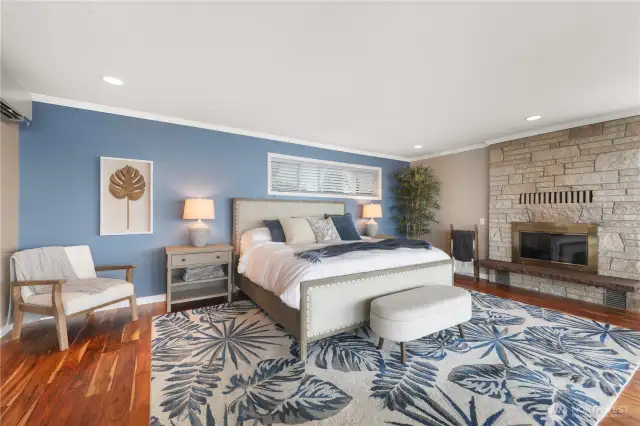 The primary bedroom is a luxurious sanctuary that blends rustic elegance with breathtaking natural beauty. At its heart is a stone fireplace, rising from floor to ceiling in warm, earthy tones-creating a cozy focal point and adding timeless character to this amazing space.