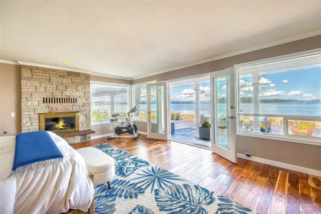 The focal point of the room is a set of elegant French doors that open wide to reveal stunning views of the water, inviting in the soft sound of waves and the scent of fresh coastal air.